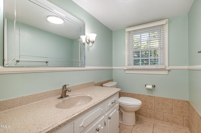 bathroom with toilet, vanity, and tile patterned flooring