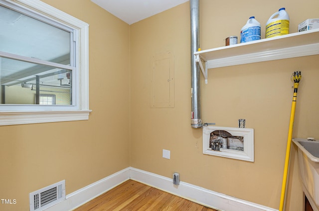 laundry area with electric panel, washer hookup, and hardwood / wood-style floors