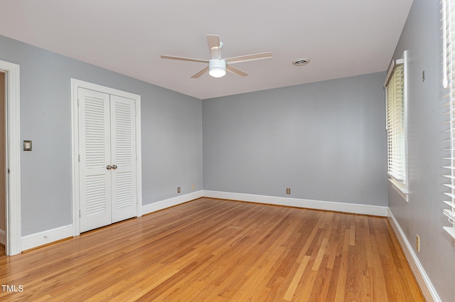 unfurnished bedroom featuring light hardwood / wood-style flooring, ceiling fan, and a closet