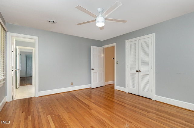 unfurnished bedroom featuring light hardwood / wood-style flooring, ceiling fan, and a closet