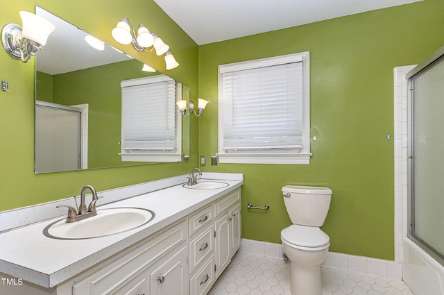 full bathroom featuring tile patterned floors, vanity, shower / bath combination with glass door, and toilet