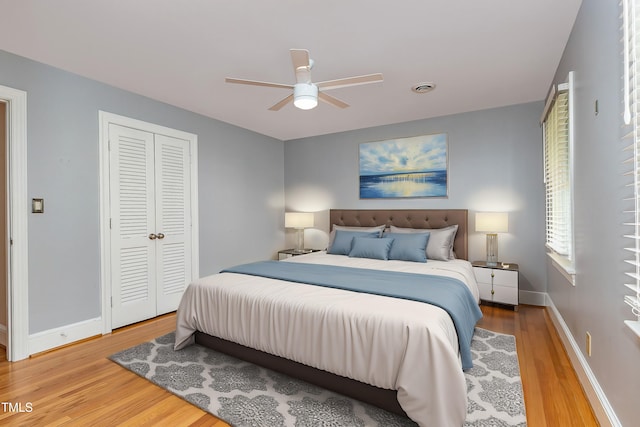 bedroom with ceiling fan, a closet, and wood-type flooring