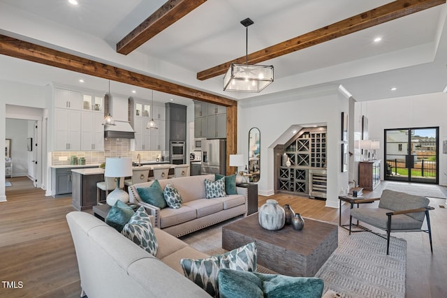 living room with sink, beam ceiling, and hardwood / wood-style flooring