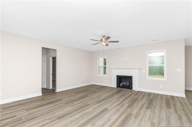 unfurnished living room with light hardwood / wood-style flooring and ceiling fan