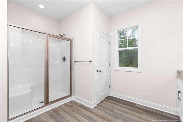 bathroom featuring walk in shower, vanity, and hardwood / wood-style flooring