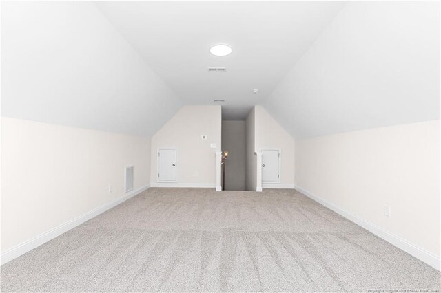 bonus room with carpet flooring and vaulted ceiling