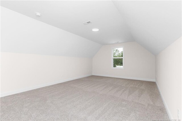 additional living space featuring lofted ceiling and carpet floors