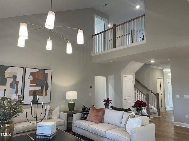 living room with hardwood / wood-style floors and a towering ceiling