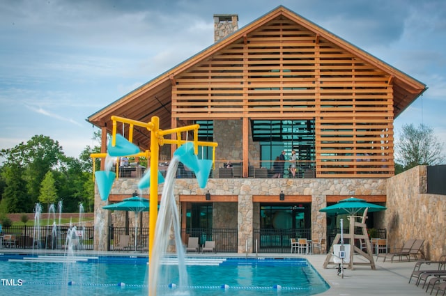 view of swimming pool with pool water feature and a patio