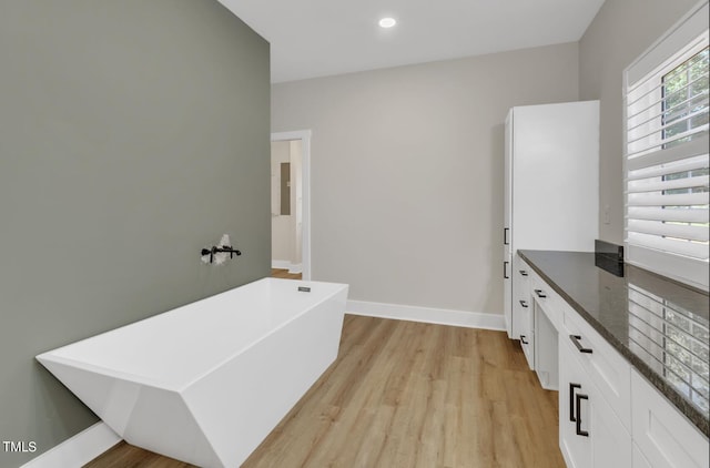 bathroom featuring a bathtub, vanity, and hardwood / wood-style floors