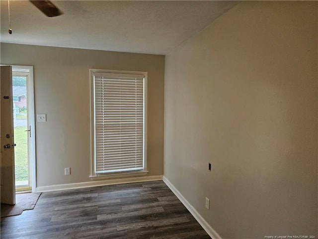 empty room with ceiling fan and dark wood-type flooring