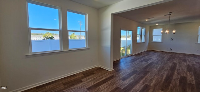 unfurnished dining area featuring a notable chandelier and dark hardwood / wood-style flooring