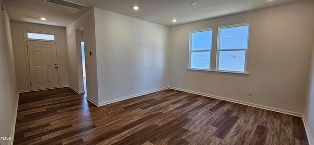 unfurnished room featuring a wealth of natural light and dark hardwood / wood-style floors