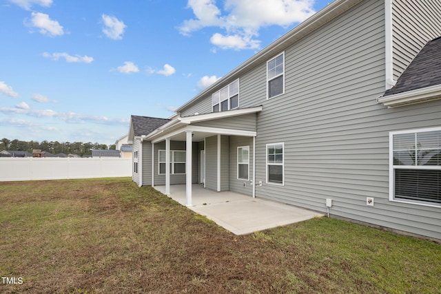 back of property featuring a patio area and a lawn