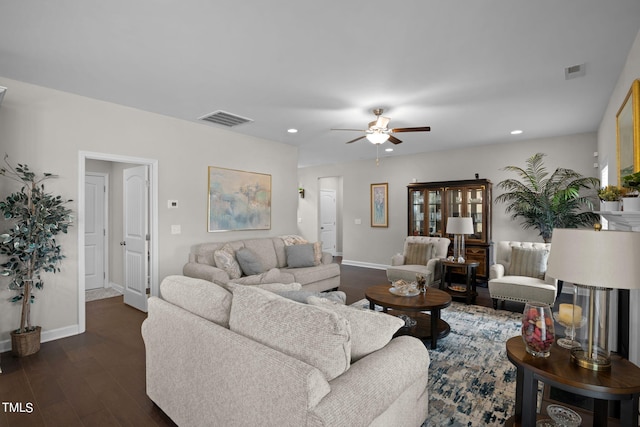 living room featuring dark wood-type flooring and ceiling fan