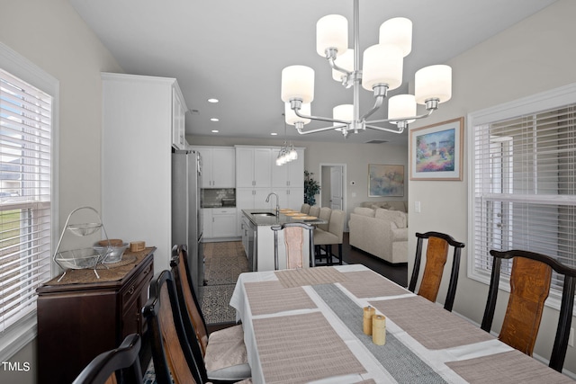 dining area featuring sink and an inviting chandelier