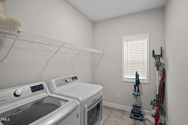 laundry area featuring washing machine and dryer and light tile flooring