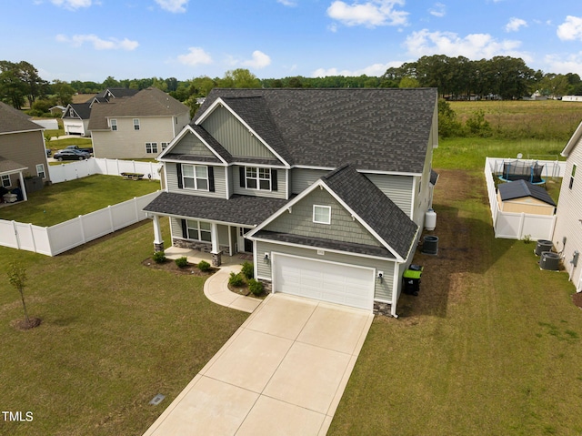 view of front of house featuring a garage, a front yard, and central air condition unit