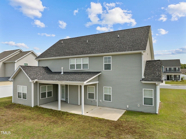 rear view of house with a lawn and a patio