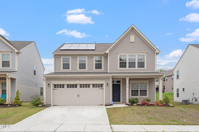 view of front of home with a front yard, solar panels, and a garage