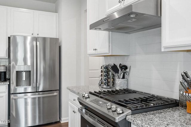 kitchen featuring white cabinetry, light stone countertops, appliances with stainless steel finishes, and backsplash