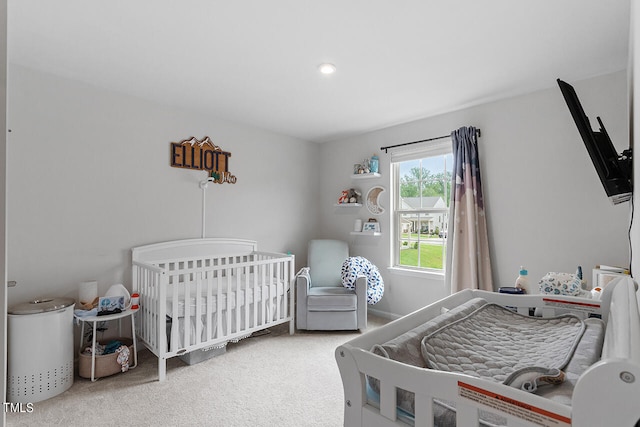 bedroom with carpet floors and a nursery area