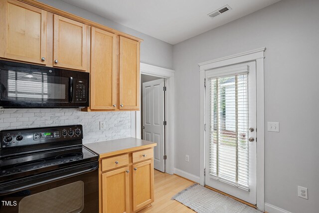 kitchen with backsplash, black appliances, light brown cabinetry, and light wood-type flooring