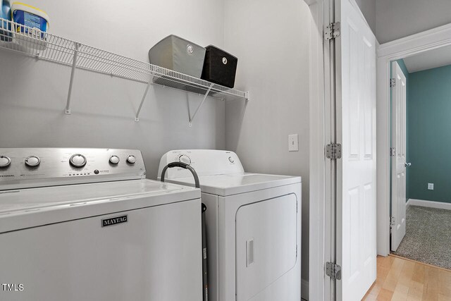 laundry area with light hardwood / wood-style floors and separate washer and dryer