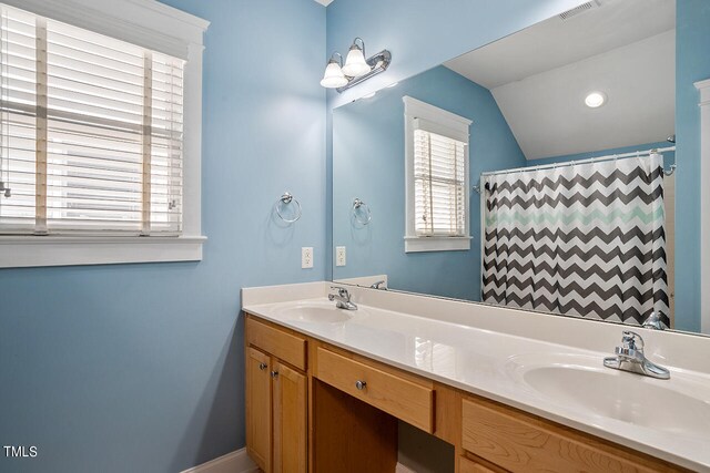 bathroom featuring lofted ceiling, a shower with curtain, a wealth of natural light, and vanity