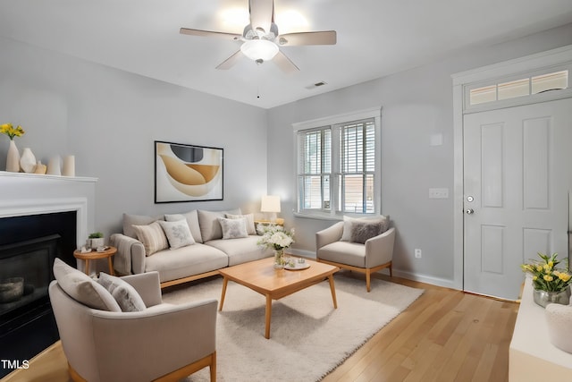 living room with ceiling fan and light hardwood / wood-style floors