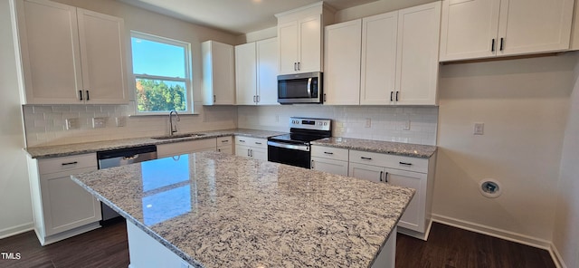 kitchen with stainless steel appliances, a center island, sink, and white cabinets