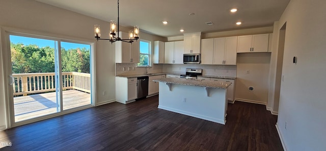 kitchen featuring white cabinetry, sink, a center island, stainless steel appliances, and light stone countertops