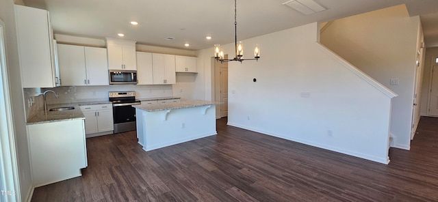 kitchen featuring stainless steel appliances, a kitchen island, sink, and white cabinets