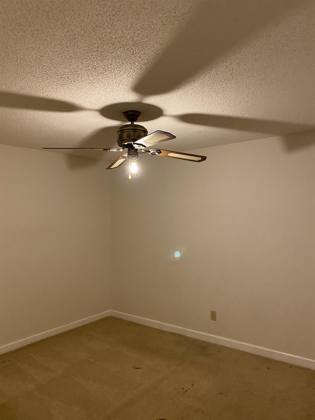 spare room with carpet, ceiling fan, and a textured ceiling