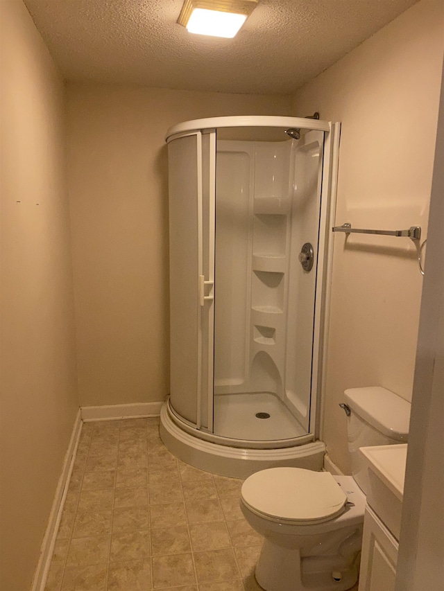 bathroom with tile flooring, vanity, toilet, and a textured ceiling