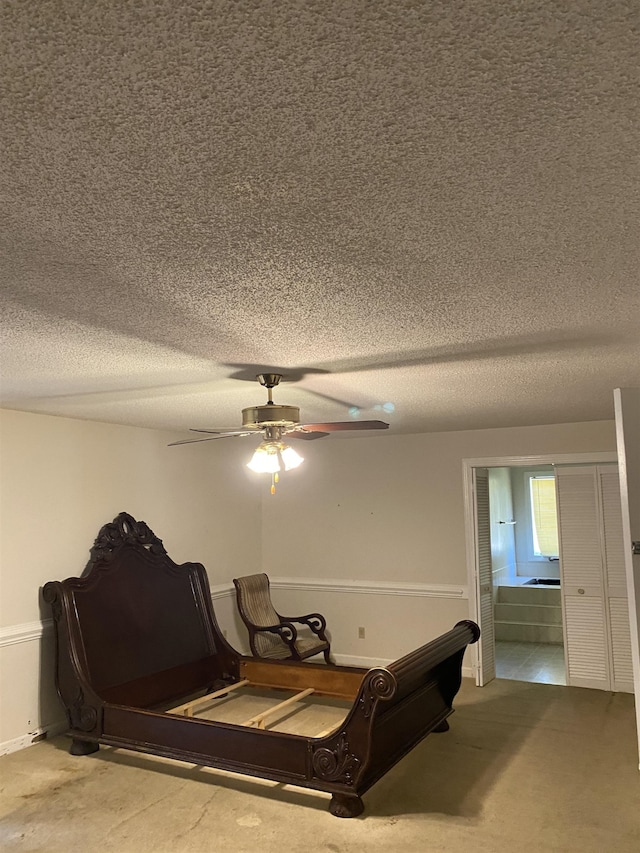 interior space with ceiling fan, a textured ceiling, and ensuite bathroom