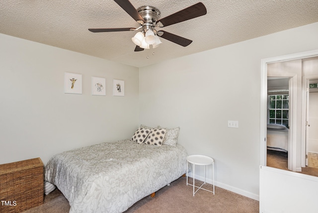 carpeted bedroom with ceiling fan and a textured ceiling