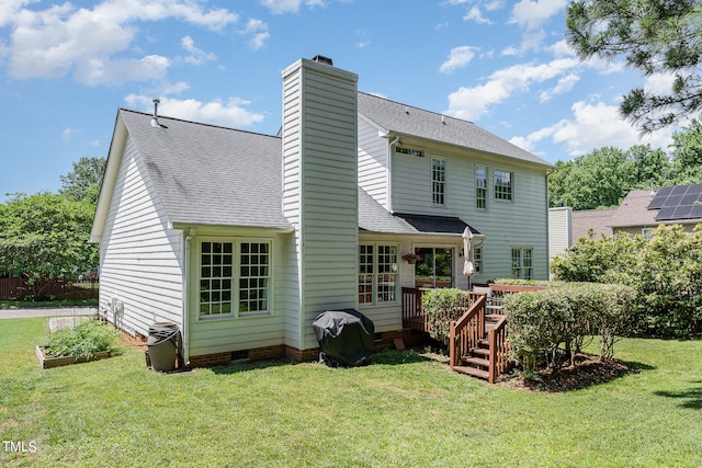 rear view of property with a deck and a yard