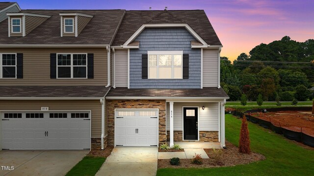 view of front of home with a garage and a lawn