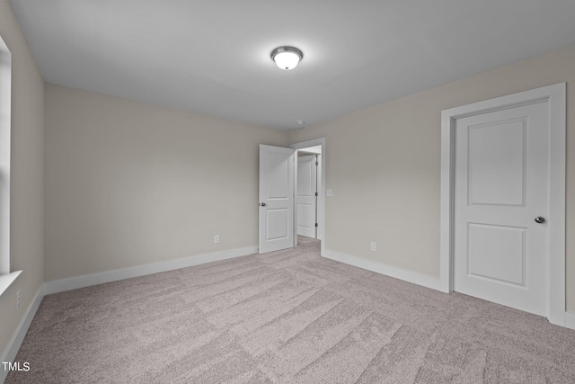 unfurnished room featuring light carpet