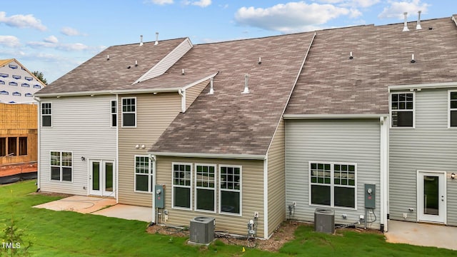 back of property featuring a lawn, a patio, and central air condition unit