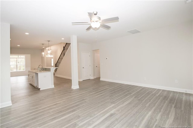 816 Red Hawk Pl, Vass, NC 28394 - unfurnished living room with light wood-type flooring, stairway, a ceiling fan, and recessed lighting
