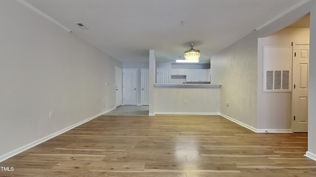 unfurnished living room with light hardwood / wood-style floors and a textured ceiling