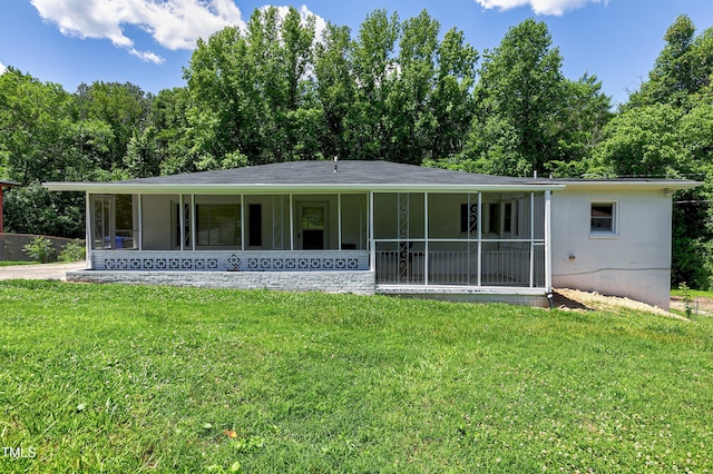 back of property with brick siding and a yard