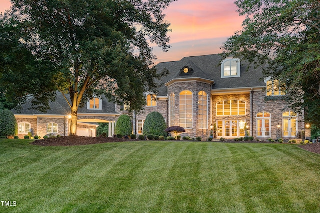 french country inspired facade featuring a lawn