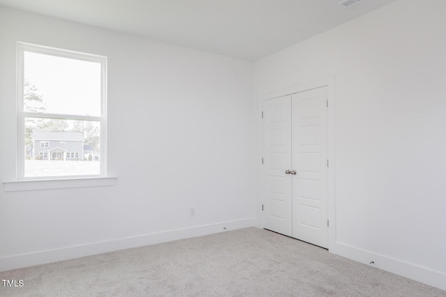 unfurnished room featuring light colored carpet