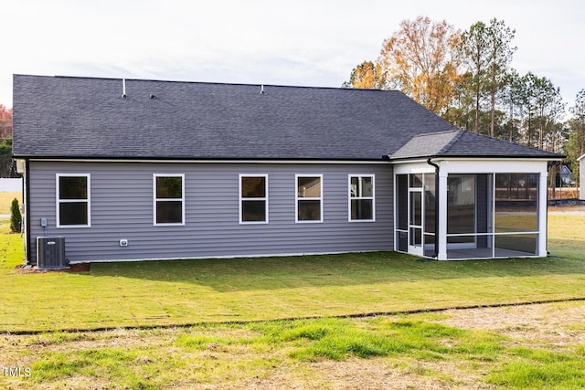 back of property featuring central air condition unit, a sunroom, and a yard