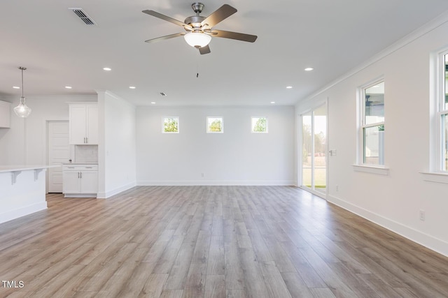 unfurnished living room featuring light hardwood / wood-style floors, ceiling fan, and crown molding