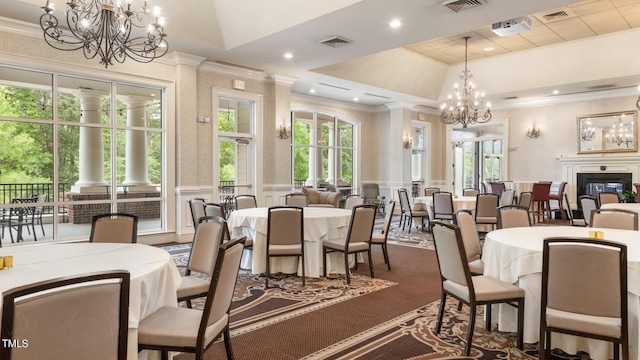 dining area with a raised ceiling, plenty of natural light, and crown molding