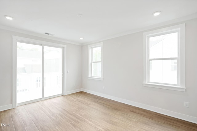 unfurnished room with light wood-type flooring and ornamental molding